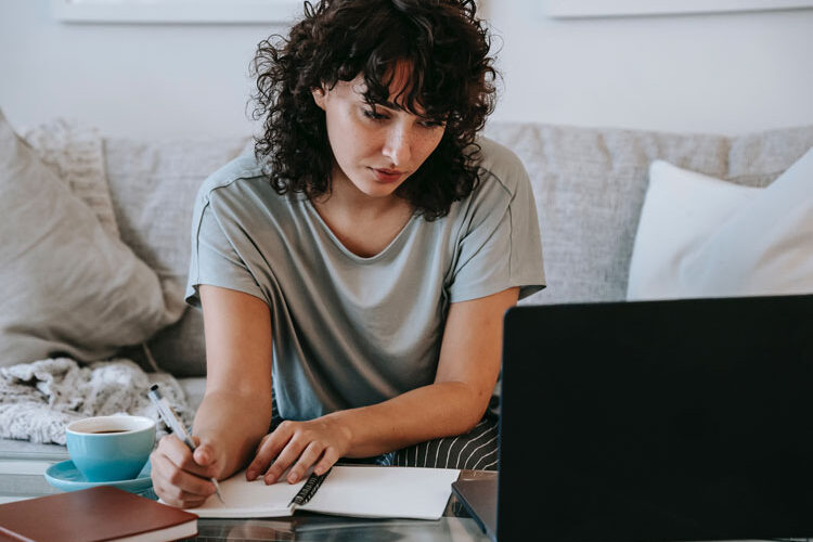 Frau beim Bewerbungsschreiben vor Laptop